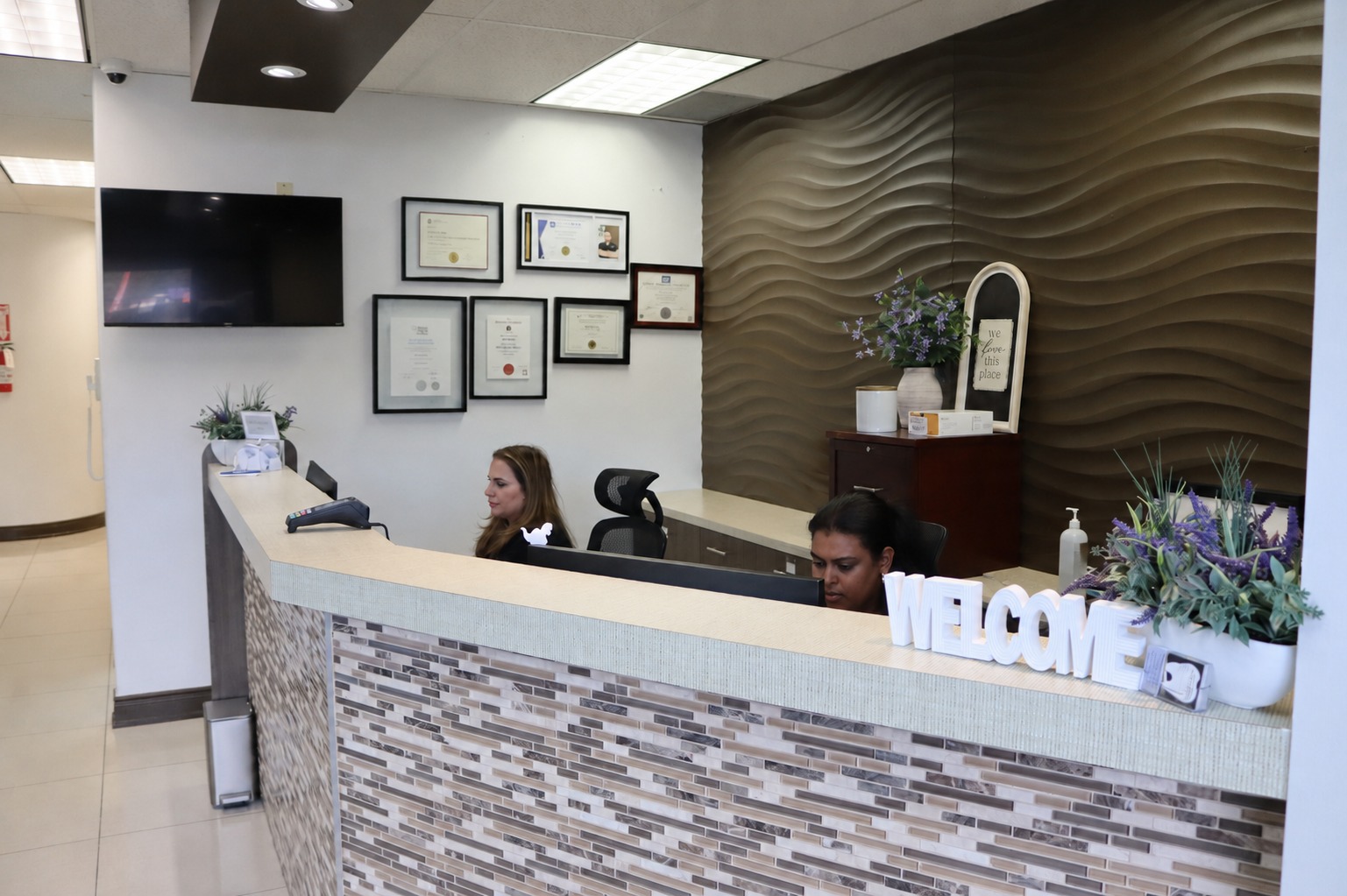 Front desk team welcoming patients at Hamilton Care Dental Centre reception in Hamilton, Ontario